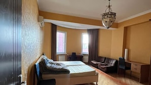 A bedroom with a bed, a desk, a chair, and a wardrobe. - Deluxe seaside Batumi  (Batumi)