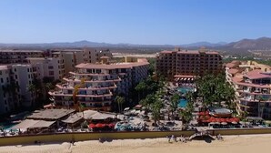 Een resort met meerdere gebouwen, een centraal gelegen zwembad en een strand.