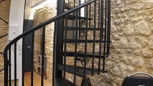 Eine Wendeltreppe mit einer Wand aus Stein im Hintergrund.