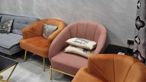 Una sala moderna con dos sillones, un sofá y una mesita.