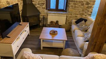 Smart-tv, een open haard, videospelletjes en boeken