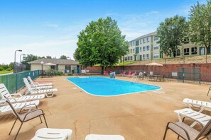 A swimming pool with lounge chairs and a brick wall. - Little House on the 12th Hole - Luxury Golf Condo (Branson)