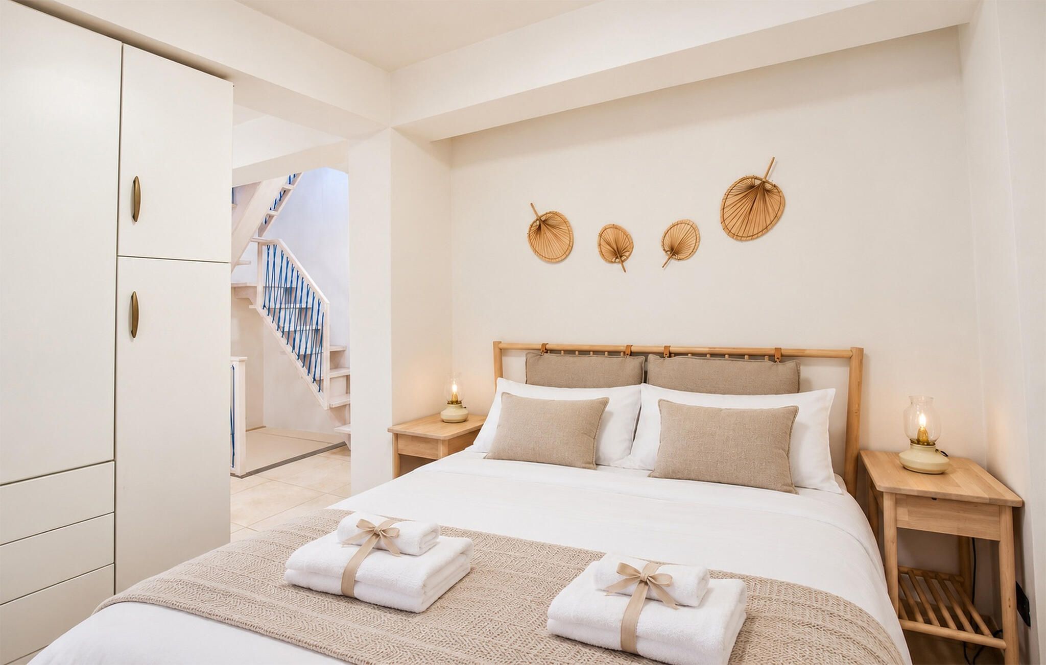 Una camera da letto con un letto, comodini, una mensola, una testiera in legno, una scala e decorazioni alle pareti.