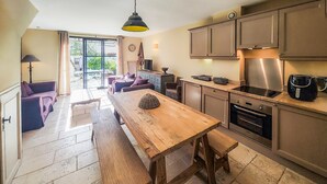 Una cucina con un tavolo in legno, mobili a incasso e un forno in acciaio inossidabile.