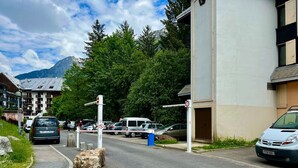 Eine Straße mit parkenden Autos und einem Gebäude mit einer Garagentür.