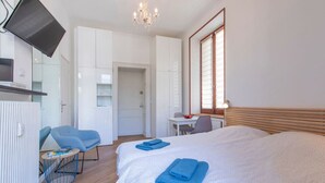 Een hotelkamer met een bed, een bureau, een stoel en een televisie.