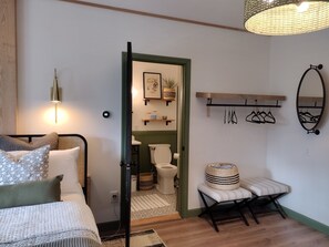 A bedroom with a bed, bedside lamp, and a view into the bathroom. - Elegant Country Retreat on Gorgeous Horse Farm, 10 min from Cooperstown! Rm #2 (cooperstown)