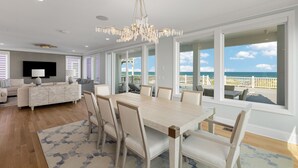 Un salón amplio con una gran mesa de comedor, asientos cómodos y vista al océano.
