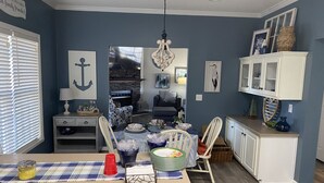 Comedor con una mesa dispuesta para cuatro personas, chimenea y vista al salón.