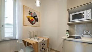 Une cuisine compacte équipée d’un four à micro-ondes, d’un petit évier et d’une table avec des chaises.