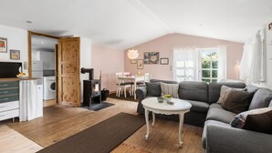 A cozy living room with a fireplace, a dining area, and a kitchen. - Nice home in Jægerspris with kitchen (Jægerspris)