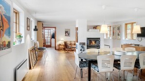 Amplia sala de estar con chimenea, mesa de comedor y asientos.