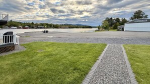 Ein Kiesparkplatz, ein Weg und ein Gebäude mit der Aufschrift 'MORSEHEAD AEBU MARINE' vor einem bewölkten Himmel und fernen Bergen.