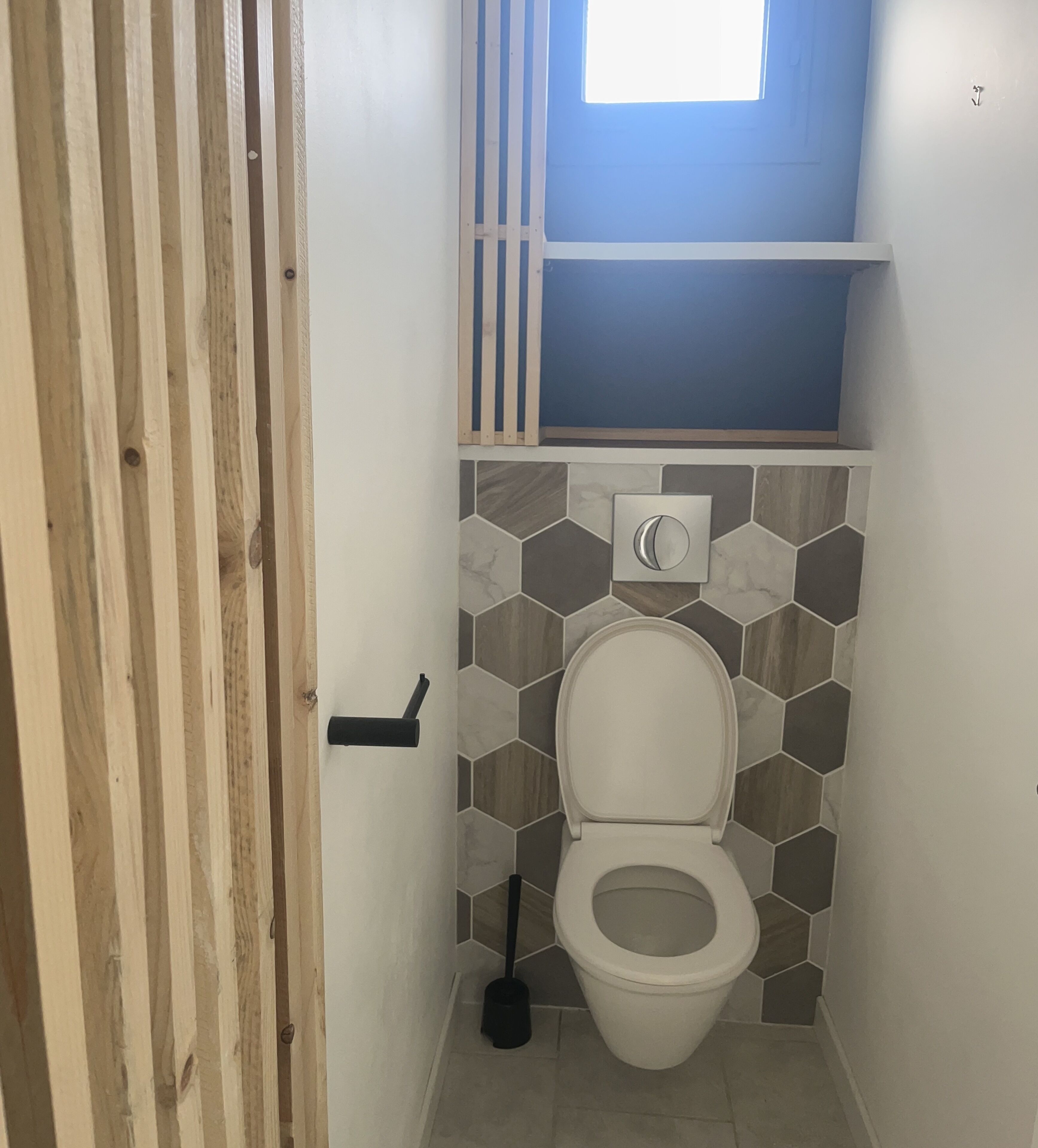 Une petite salle de bain avec des toilettes, un bidet et une fenêtre.