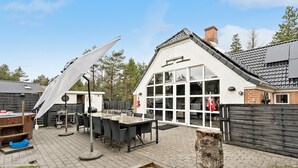 Eine Terrasse mit Sitzgelegenheiten und einem großen Fenster.
