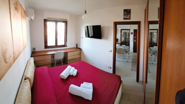 A hotel room with a bed, a desk, a chair, a TV, and a window. - Park Snail - Alghero Loc. Caragol   (Alghero)