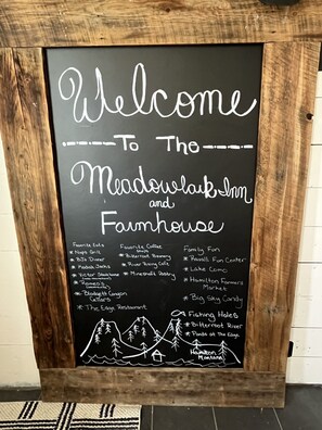 A welcome signboard for Meadowlark Inn and Farmhouse, listing favorite eats, coffee shops, family fun, and fishing holes. - 1895 Luxury Farmhouse - Blodgett Canyon View -Sleeps 13 (Hamilton)