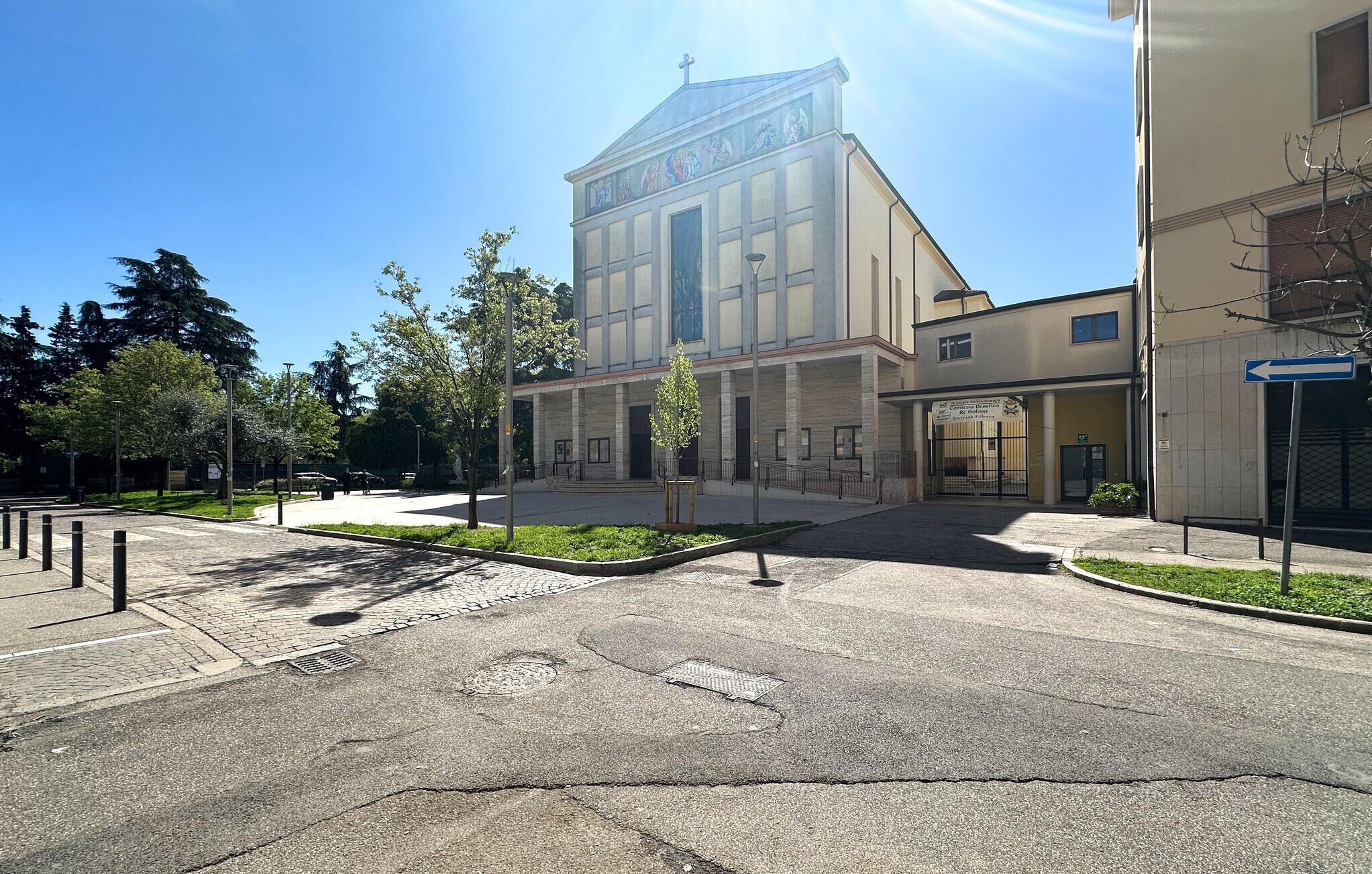A building with a large entrance, a cross on top, and a sign indicating it's a religious building.