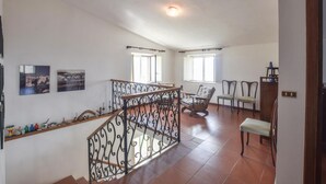 A spacious living area with a wooden staircase, two windows, and a bench. - Nice home in Cetraro - San Pietro (Cetraro - San Pietro)