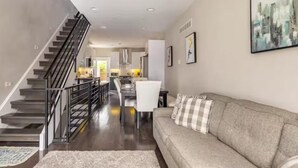 Un intérieur moderne comprenant un escalier, un coin repas et un salon.