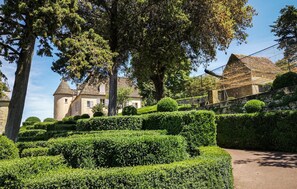 A well-maintained garden with neatly trimmed hedges and a traditional building with a tower. - Cozy home in Saint-Agne (Saint-Agne)