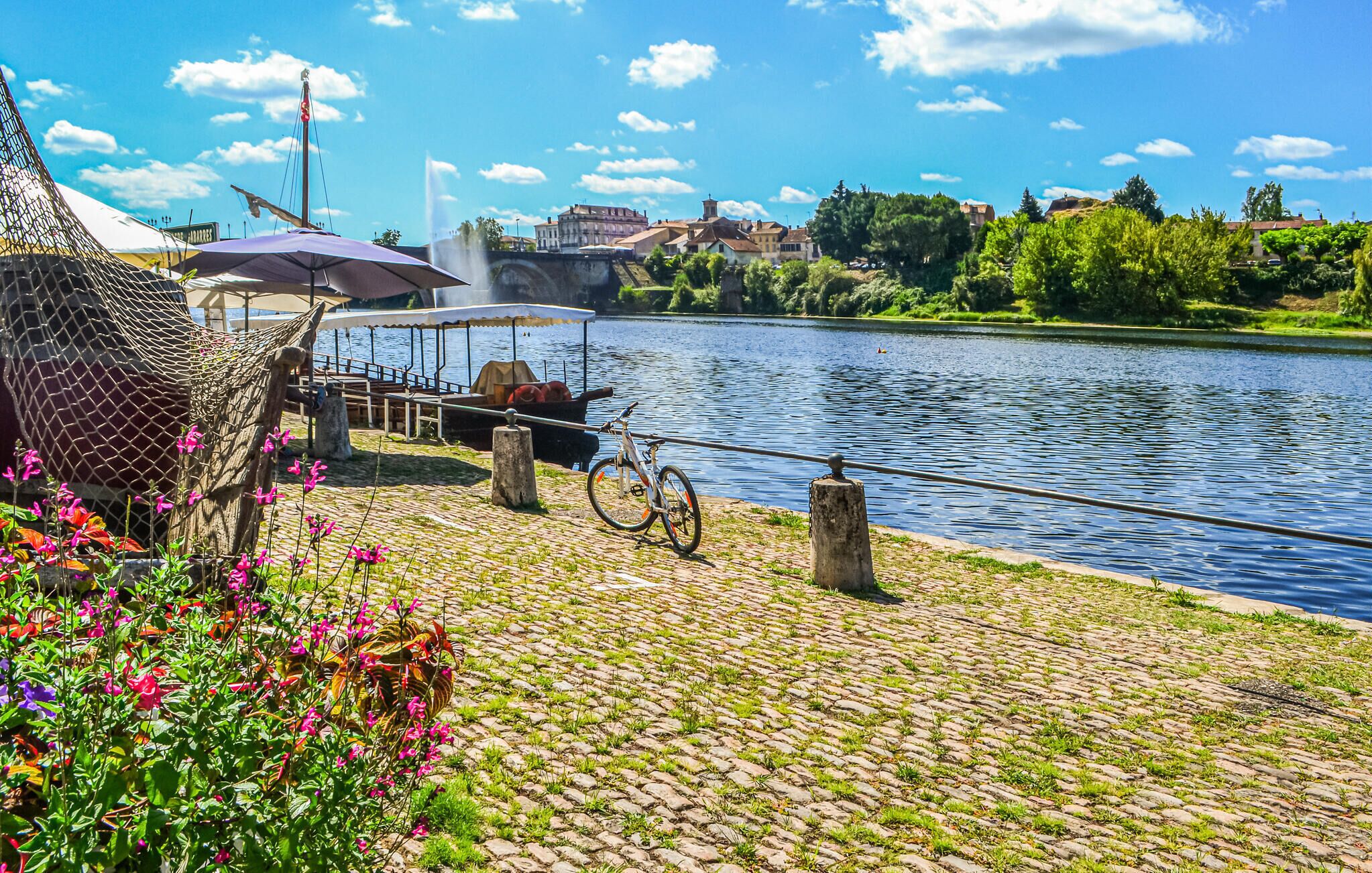 Una passeggiata lungo il fiume con bicicletta, zona relax coperta e un pontile per barche.
