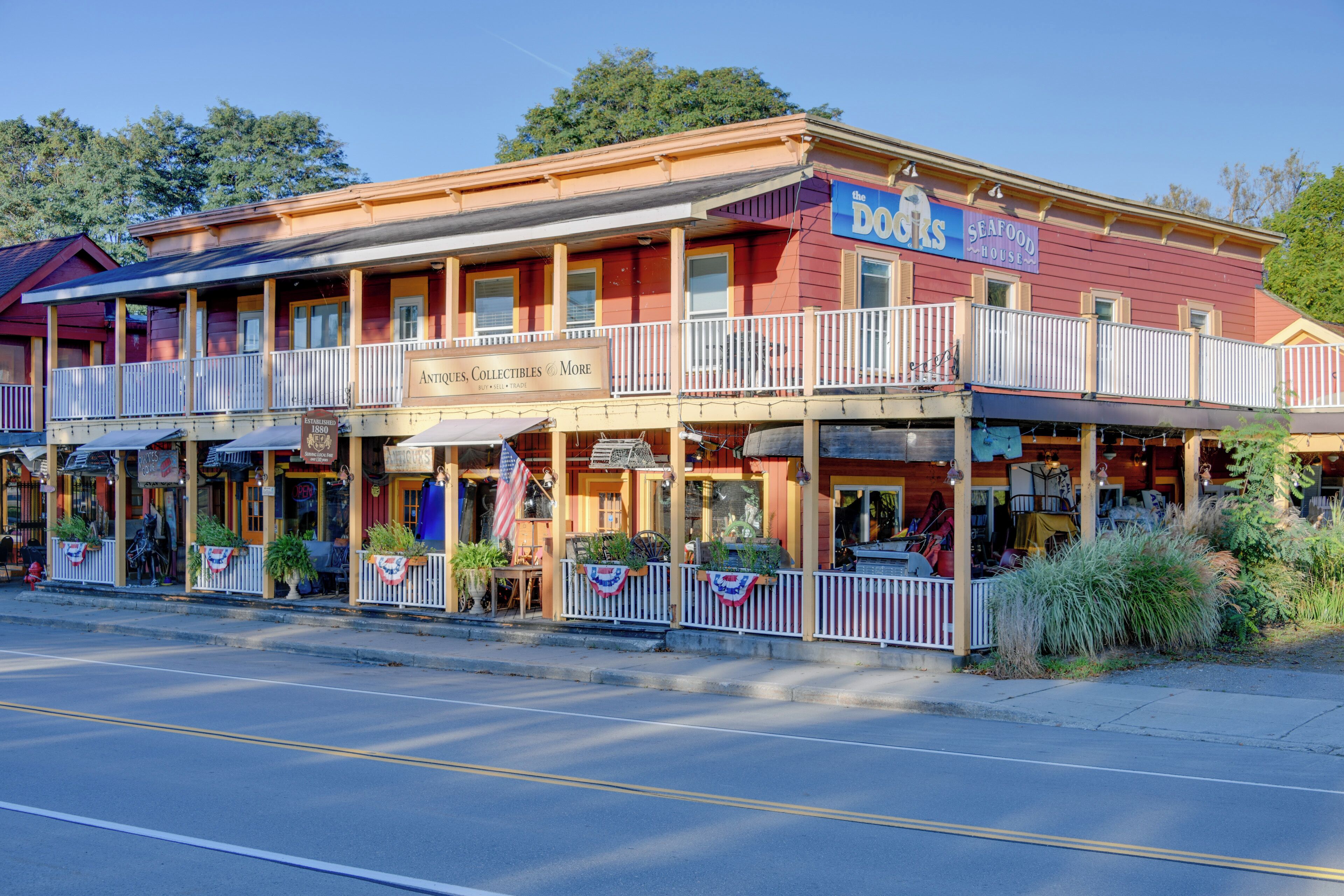 A two-story building with a red facade, a balcony with white railings, and a sign for 'The Dogs Seafood House'.