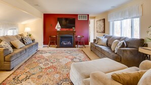 A living room with two sofas, a fireplace, and a patterned rug. - Chautauqua Lake Access: Waterfront Cottage w/ Dock (Mayville)