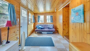 Interior de una cabaña con un sofá, un escritorio, una lámpara y un cartel que dice 'Float Rentals'.