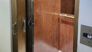 Un ascensor con interior de madera y detalles metálicos.