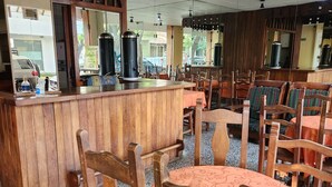 Un restaurante con mobiliario de madera, una barra y vistas a la calle.