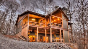 A large, multi-level wooden cabin with a balcony and a stone foundation. - Eagles on the Ridge - Nearby River Access | Hot Tub | Game Room (Blue Ridge)