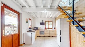 Une cuisine moderne avec un escalier en bois, un four encastré et un réfrigérateur.