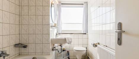 Une salle de bain avec une baignoire, des toilettes et un lavabo.