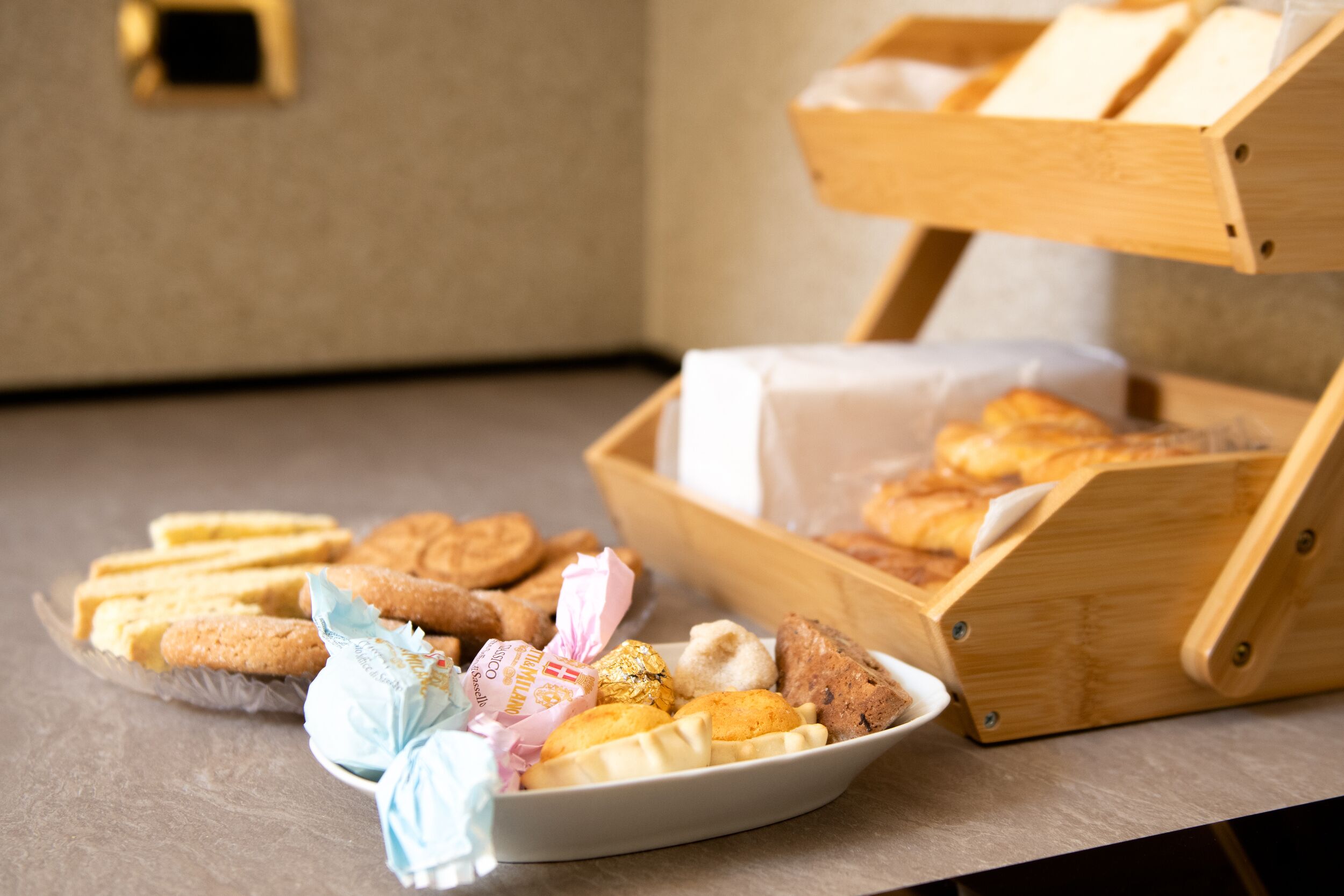 A wooden box with a tray of assorted cookies and pastries on a table.