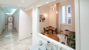 Un interior moderno con zona de comedor, pasillo y vista al exterior.