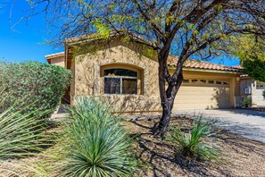 A stucco house with a tiled roof, a garage, and a well-maintained garden with agave plants. - Entire home ~ Quiet Getaway ~ Spacious and Comfortable ~ Chef's Kitchen! (Tucson)
