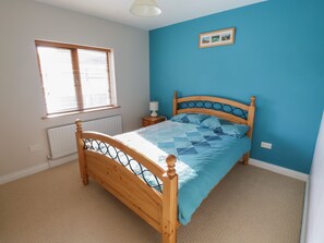 A bedroom with a wooden bed, a window with blinds, a radiator, and a picture on the wall. - SWAN LAKE, family friendly, with open fire in Boyle, County Roscommon (BOYLE)