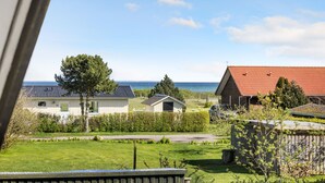 Un quartiere residenziale con case, vista mare e prato.