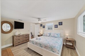 Cozy retreat with a mountain-themed bedspread, dresser, and mirror, perfect for a comfortable stay.