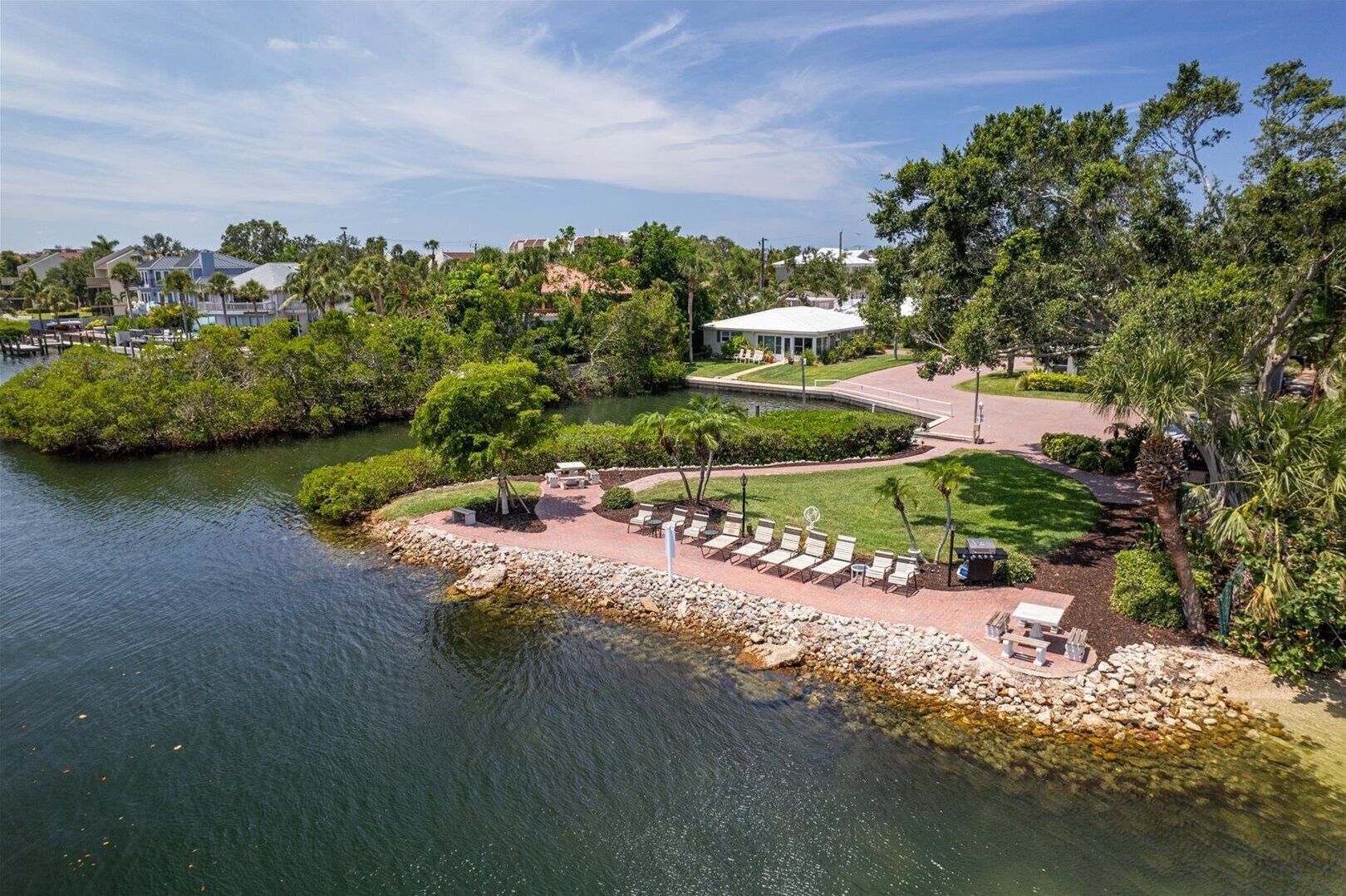 Un resort junto al lago con zona de patio, sillas de descanso y un pabellón.