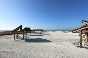 Una spiaggia con strutture in legno e lettini.