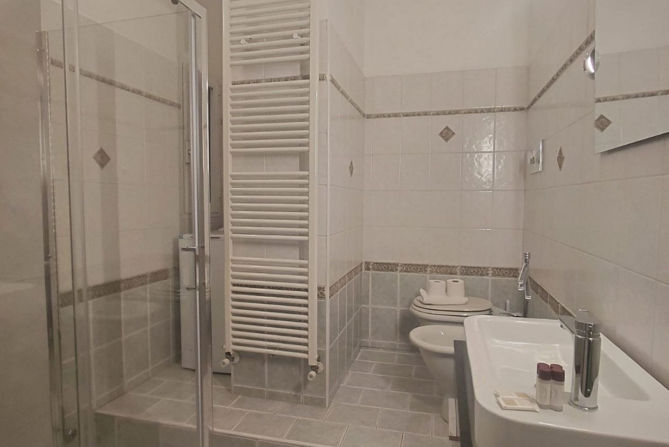 Un baño con cabina de ducha de vidrio, una bañera blanca, un inodoro y un lavabo.