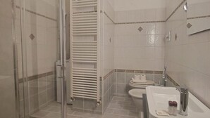 A bathroom with a glass shower enclosure, a white bathtub, a toilet, and a sink. - GuestHost - The apartment, a welcoming residence of approximately 70 square meters, is ideal for hosting up to 4 people. Located on the first floor of a building with elevator in the Washington district, one of the most elegant residential areas of Milan (Milano)
