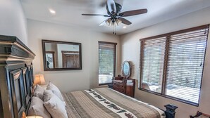 A bedroom with a bed, a ceiling fan, a dresser, a mirror, and two windows with blinds. - Hot Tub & Mtn Views - Modern Build, Pet-Friendly, 14 mi to Breck (Alma)