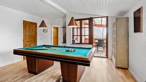 A pool table in a room with wooden floors, white walls, and a sloped ceiling. - 4 bedroom awesome home in Rudkøbing (Rudkøbing)