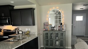 A modern kitchen with dark cabinets, a granite countertop, and a built-in oven. - Family home (Roseburg)
