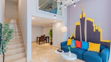 Suite Confort, 1 cama de matrimonio grande | Zona de estar | Televisión LCD de 55 pulgadas con canales por cable