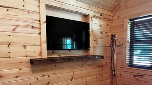 Una habitación con paredes de madera y un mueble empotrado para la televisión.