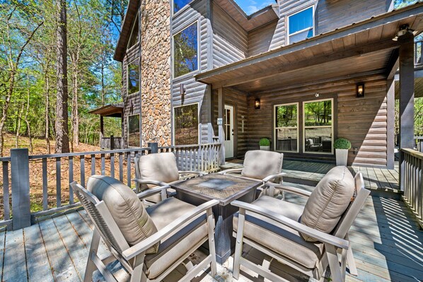 A wooden deck with outdoor furniture and a stone wall.